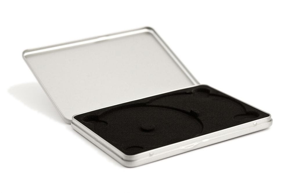 Geöffnete rechteckige DVD-Metalldose aus silberfarbenem Metall mit samtbezogenem schwarzen Inlay für zwei DVDs, auf weißem Hintergrund fotografiert.
